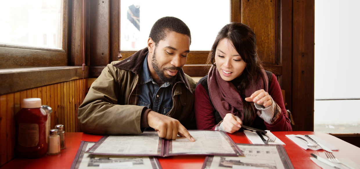 a couple looking through an optimized restaurant menu design