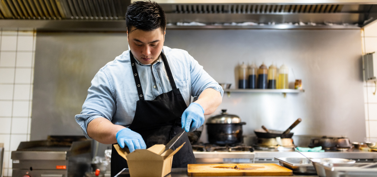 chef putting the finishing touches on his delivery menu